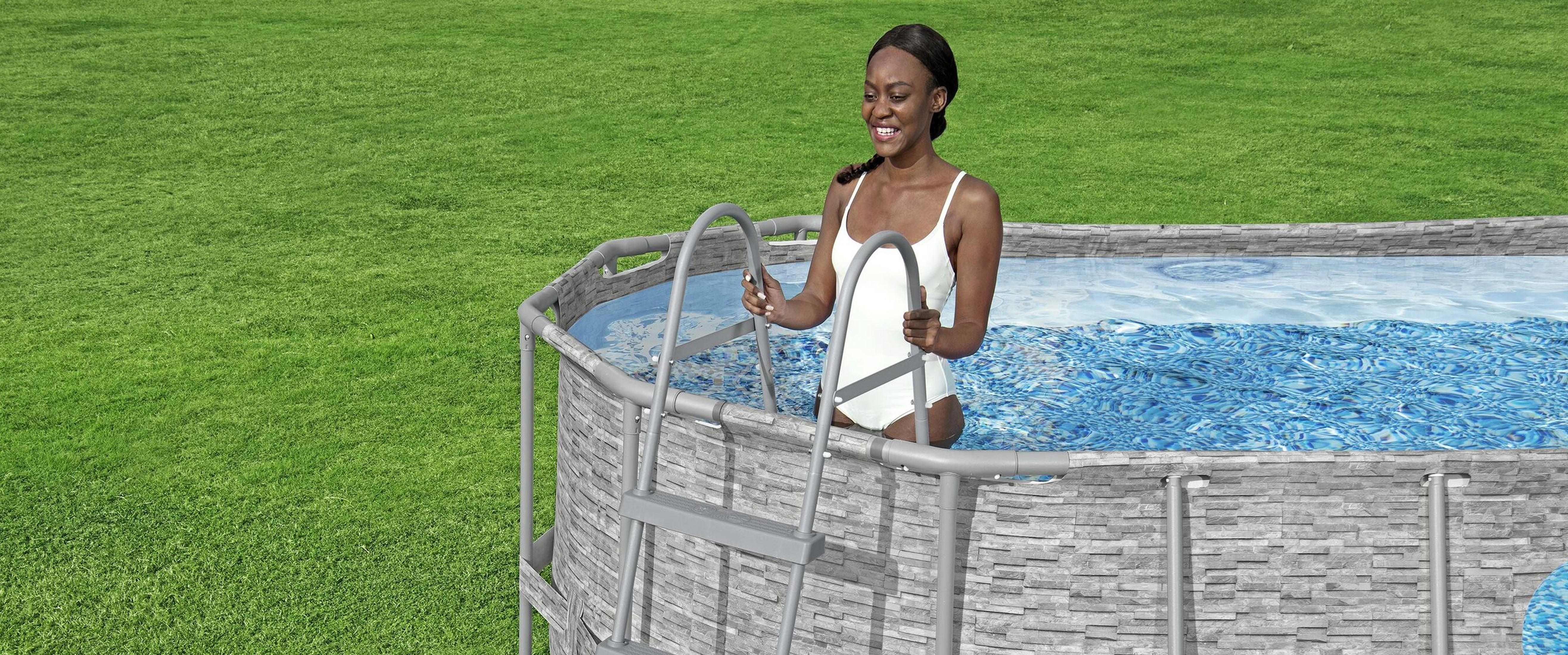 A woman wearing a white swimsuit is climbing up a Bestway pool ladder to get out of her Bestway above ground pool.